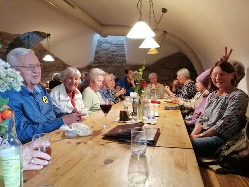 Mitglieder der Betreuungsgruppe sitzen am Tisch im Gewölbekeller.