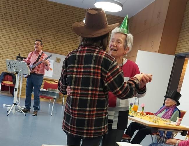 Bild mit dem Musiker an der Gitarre und einem Gästpaar beim Tanz